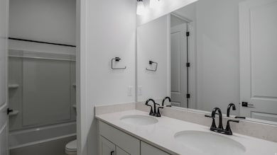 Full bathroom featuring double vanity and shower / washtub combination