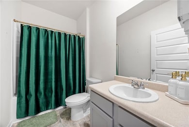 Full bath featuring toilet, vanity, a shower with 