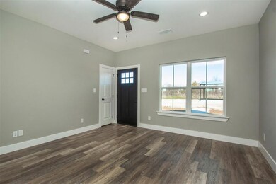 Entryway with ceiling fan and dark wood-type flooring