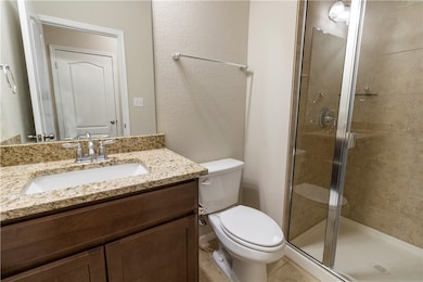 Bathroom with toilet, a textured wall, a shower st
