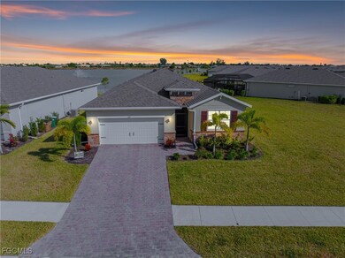 View of front of house with stone siding, a yard, decorative driveway, and an attached garage