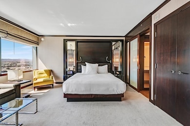 Carpeted bedroom featuring crown molding and two closets