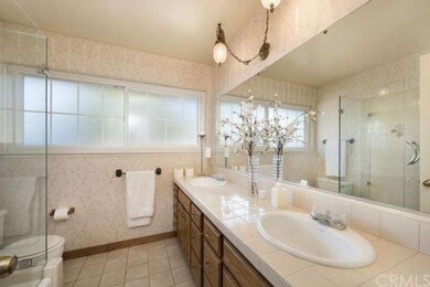 The guest bathroom features a frameless glass show