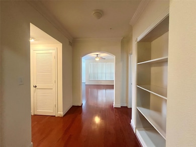 Hallway featuring dark wood-style flooring, crown