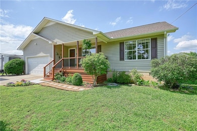 Ranch-style home featuring covered porch, a garage