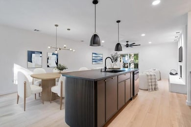 Kitchen featuring a sink, dark countertops, open 