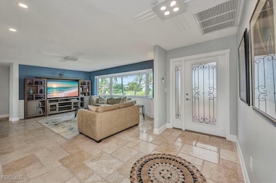 Foyer entrance with stone tile flooring and recessed lighting
