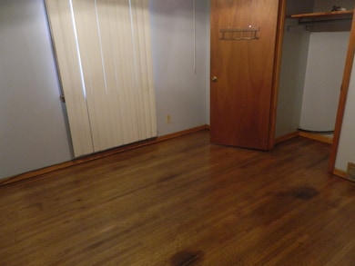 Unfurnished bedroom with dark hardwood / wood-styl