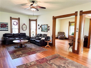 Living room featuring a textured ceiling, a ceiling fan, and wood finished floors