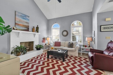 Living room featuring ceiling fan, a fireplace, an