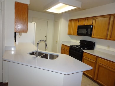 Kitchen featuring black appliances, brown cabinet