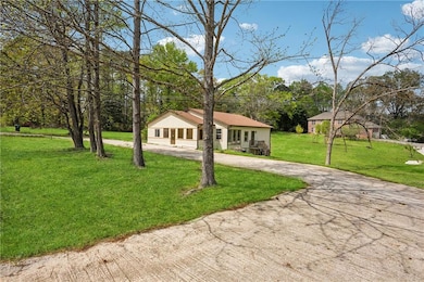 View of front facade with curved driveway and a front lawn