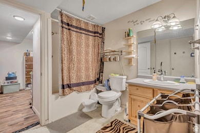 Bathroom with vanity, shower / bath combination with curtain, and light tile patterned floors