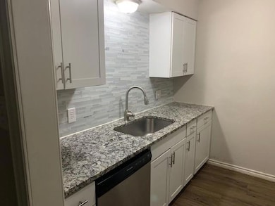 Kitchen featuring white cabinets, a sink, decorati