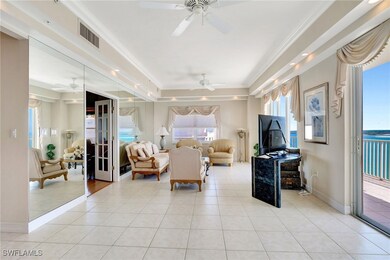Living room featuring visible vents, crown molding, ceiling fan, and light tile patterned floors