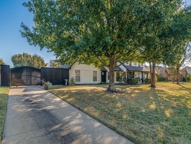 View of front of property featuring concrete driveway, a gate, and a porch