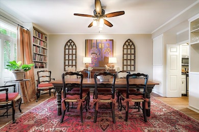 Dining space featuring a ceiling fan, light wood finished floors, and crown molding