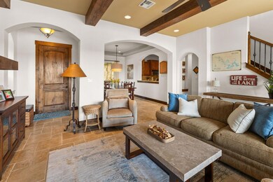 Living area featuring stone tile flooring, beam c