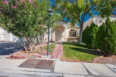 Mediterranean / spanish house with a front lawn, stucco siding, a garage, driveway, and a tile roof