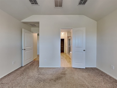 Unfurnished bedroom featuring vaulted ceiling and light carpet