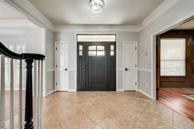 Tiled foyer with crown molding