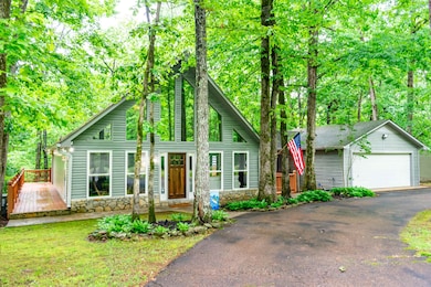 View of front of property with a wooden deck, a de