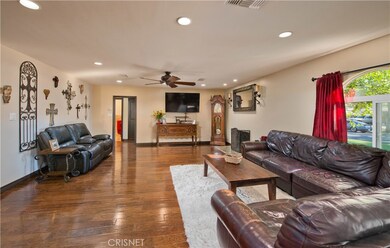 Large open living area with wood floors and recessed lighting.