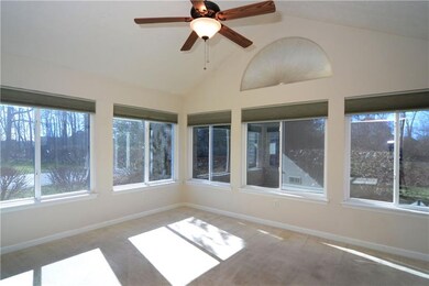 SUNROOM/DEN HAS WALLS OF WINDOWS, NEUTRAL CARPET A