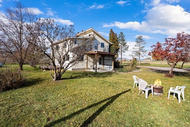 Back of house featuring an outdoor fire pit, a yard, and a patio