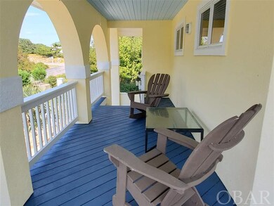 Front side of wraparound porch with table and rock