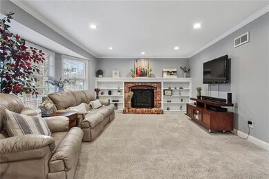 Family room has brick fireplace and bookcase w/adj
