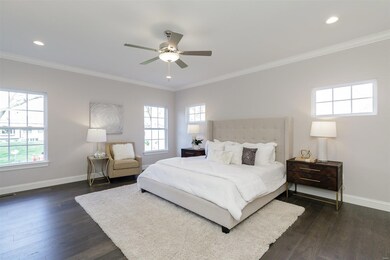 Main Floor Master Bedroom Suite with Crown Molding and Recessed Lighting