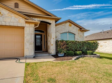 Property entrance with stone siding and a lawn