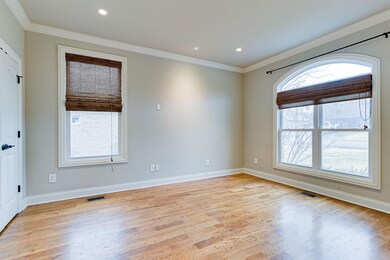 Front spare bedroom located on the main level with double closets, LED recessed lights, solid hardwood floors and crown molding . . . overlooks front yard