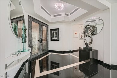 Hallway with tile patterned flooring, a tray ceili