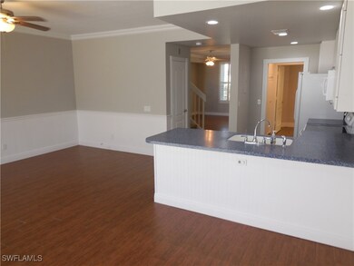 Kitchen with white cabinets, dark wood-type floori