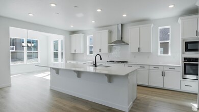 Kitchen with decorative backsplash, stainless steel oven, a breakfast bar area, healthy amount of natural light, and recessed lighting