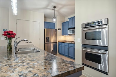 Kitchen featuring blue cabinets, decorative light 