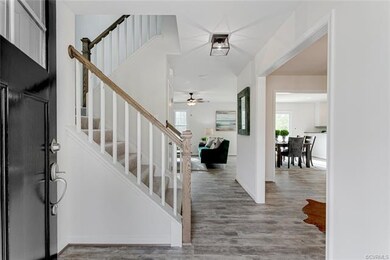 Foyer Opens to Beautifully Trimmed Staircase.