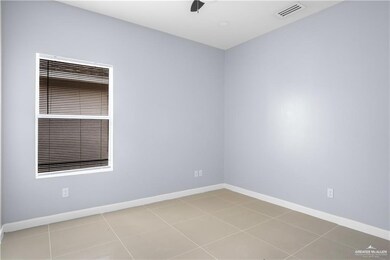 Spare room featuring baseboards and light tile patterned flooring