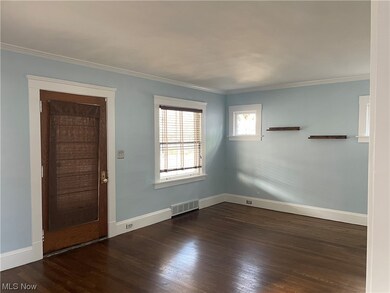 Empty room with wood-flooring and ornamental molding