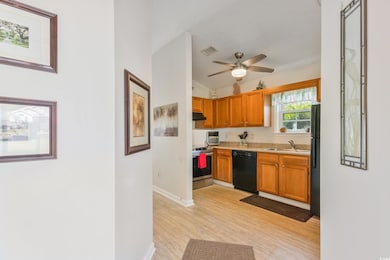 Kitchen with dishwasher, stainless steel range with electric cooktop, a sink, freestanding refrigerator, and light wood finished floors
