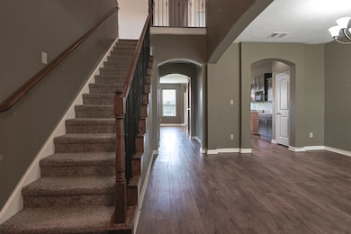 Foyer with a towering ceiling and dark hardwood /