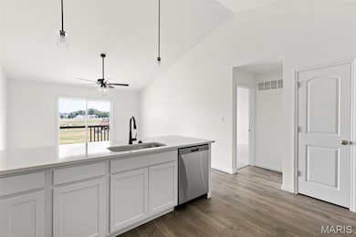 Kitchen featuring vaulted ceiling, white cabinets, dishwasher, dark wood finished floors, and a ceiling fan