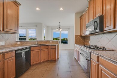 Kitchen featuring black appliances, a sink, plent