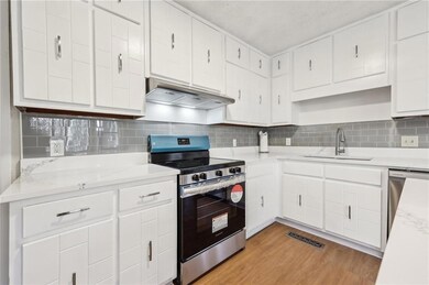 Kitchen featuring extractor fan, white cabinetry, 