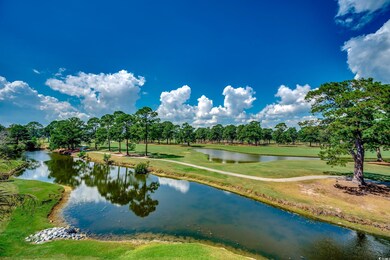 Water view featuring a tree filled landscape and a golf course