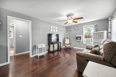 Living room featuring ceiling fan and dark hardwoo