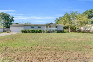 View of front facade featuring a porch, a garage, 