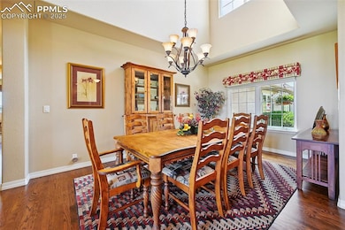 Dining space featuring a chandelier, wood finished floors, and a high ceiling